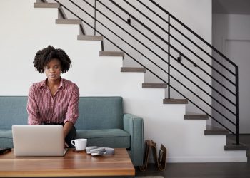 young business woman sitting on sofa planning her insurance